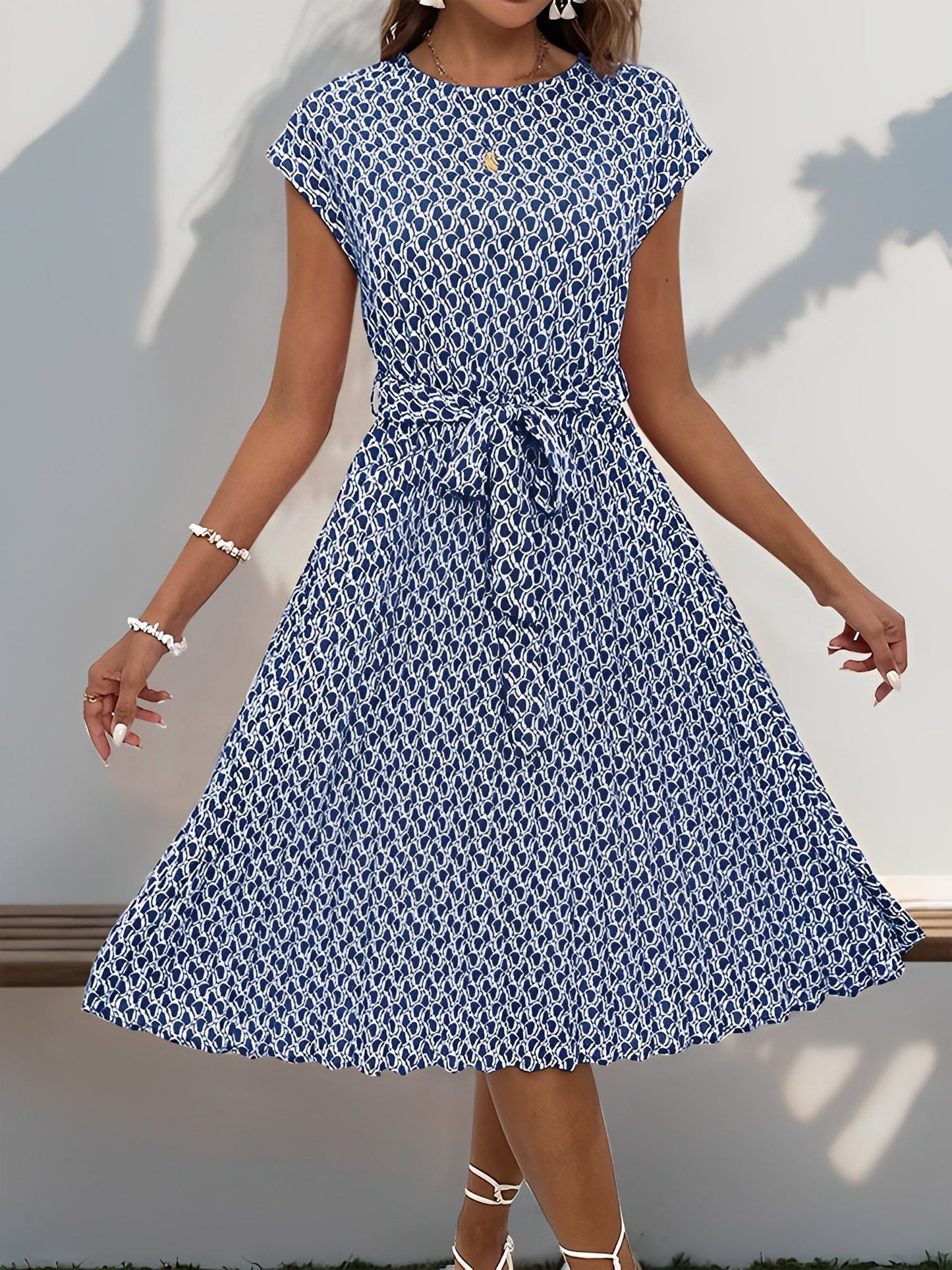 Navy Blue - Woman wearing a woven floral cap-sleeve midi dress with a self-tie waist and pleated skirt.