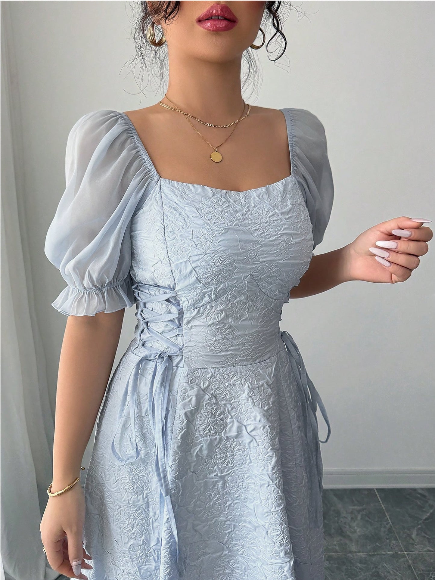 Grey Blue - Model wearing a textured jacquard A-line maxi dress with sheer puff sleeves and side lace-up bodice detailing.