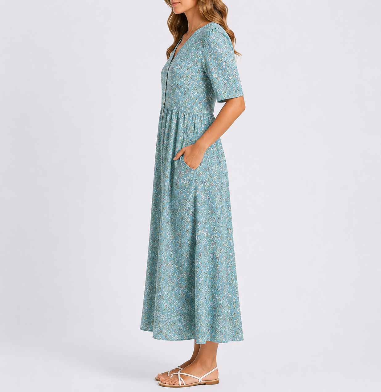 Woman wearing a floral print short-sleeve smock midi dress with a gathered waist and side pockets.