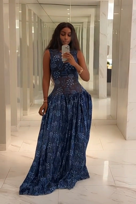 Blue - A woman wearing a sleeveless maxi dress featuring a fitted, semi-sheer geometric bodice and a voluminous gathered skirt with a mixed abstract blue print.