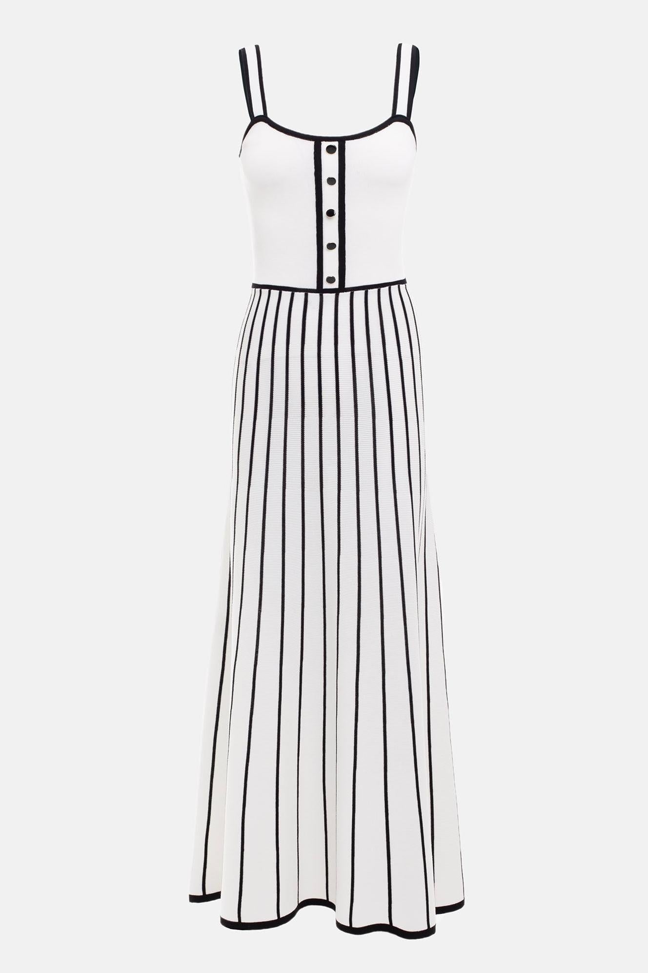 White - Woman wearing an elegant off-white midi knit dress with black contrast binding on the square neckline and straps, a buttoned bodice, and a flared A-line skirt featuring black vertical stripes.