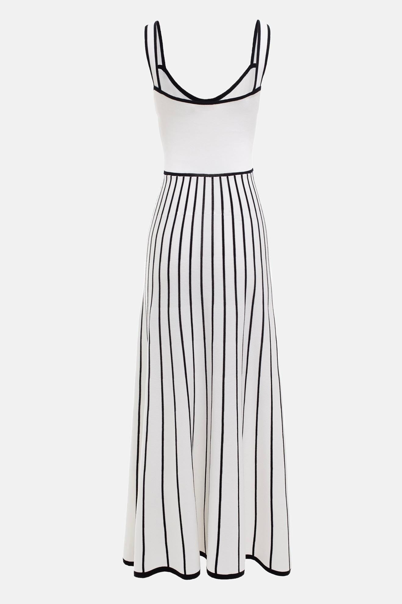 White - Woman wearing an elegant off-white midi knit dress with black contrast binding on the square neckline and straps, a buttoned bodice, and a flared A-line skirt featuring black vertical stripes.
