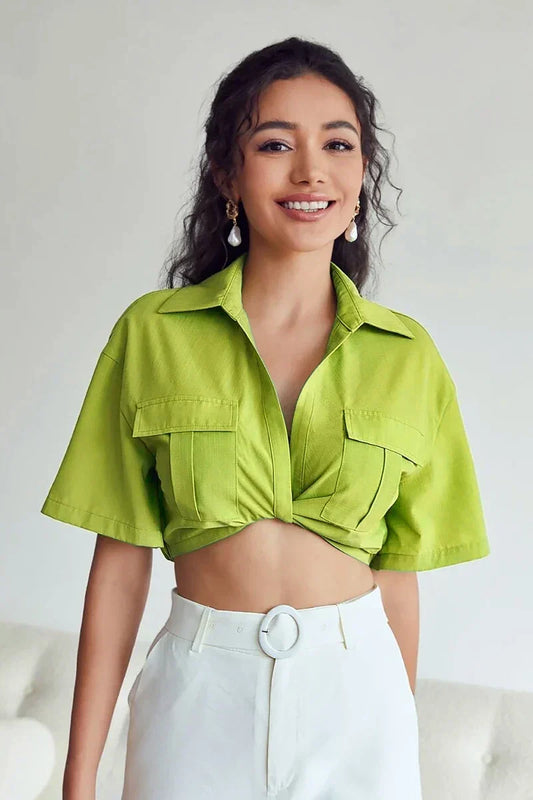 Women's bright green short-sleeve cropped shirt featuring a collared V-neckline, two large chest utility pockets, and a stylish twist-front hem.