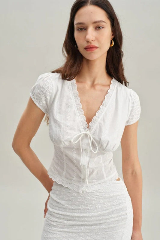 White - Women's white short-sleeve tailored blouse featuring intricate floral embroidery, a deep V-neckline with scalloped lace trim, and a delicate tie-front detail at the bust.