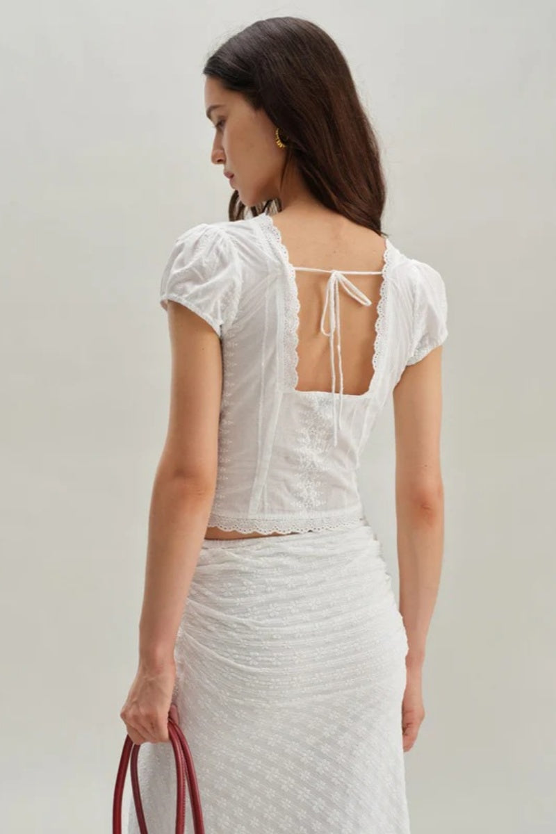 White - Women's white short-sleeve tailored blouse featuring intricate floral embroidery, a deep V-neckline with scalloped lace trim, and a delicate tie-front detail at the bust.