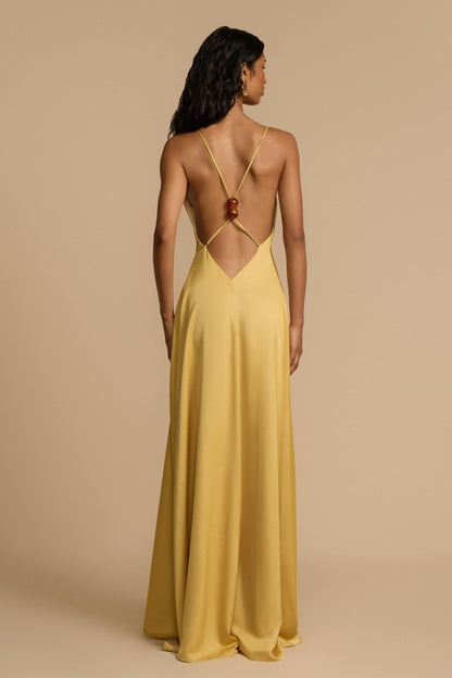Gold - A woman modelling an elegant, floor-length golden yellow sleeveless maxi dress featuring a deep plunge V-neckline and a smooth, flowing skirt with a subtle satin-like sheen.
