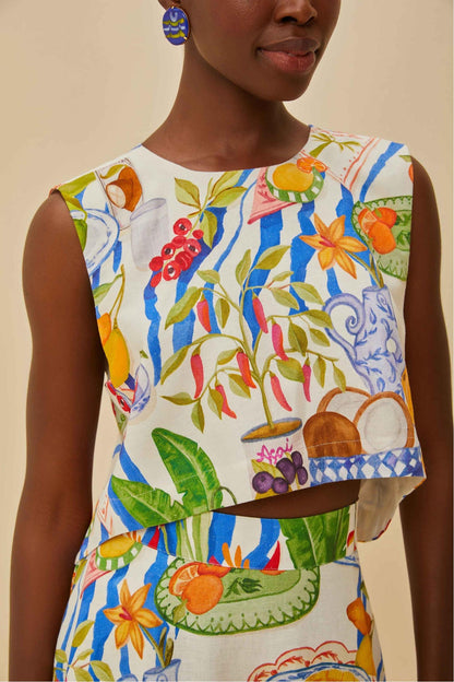 Colorful - Woman wearing a vibrant two-piece co-ord set featuring a sleeveless crop top and high-waisted A-line midi skirt, adorned with a colourful tropical fruit and plate print.