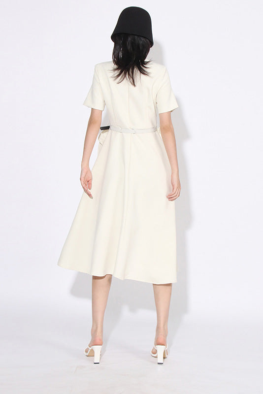 White - A woman wearing a bright red, short-sleeved midi dress featuring a notched V-neckline, a thin waist belt, and two large 3D rosette embellishments on the A-line skirt.