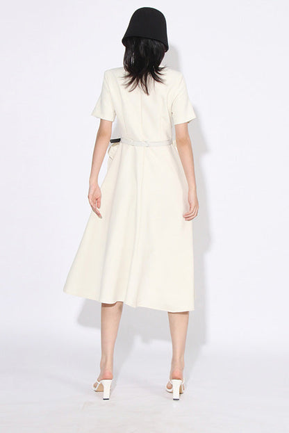 White - A woman wearing a bright red, short-sleeved midi dress featuring a notched V-neckline, a thin waist belt, and two large 3D rosette embellishments on the A-line skirt.