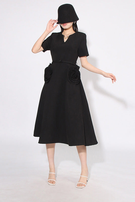 Black - A woman wearing a bright red, short-sleeved midi dress featuring a notched V-neckline, a thin waist belt, and two large 3D rosette embellishments on the A-line skirt.