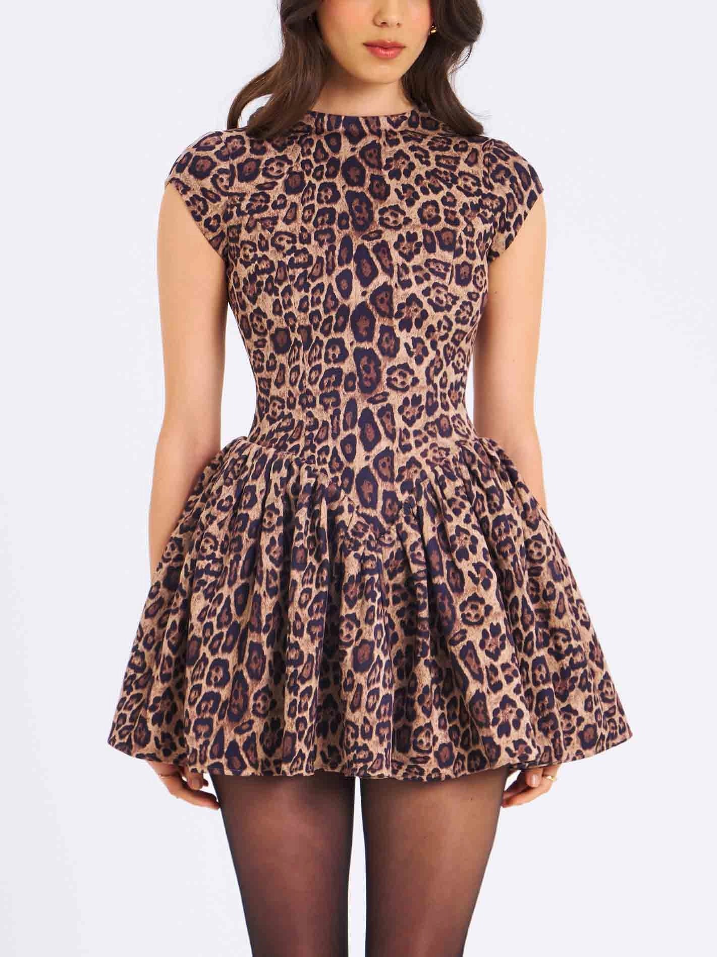 Women's high-neck, cap-sleeve mini dress featuring a fitted bodice, a gathered drop-waist skirt, and an all-over leopard print.