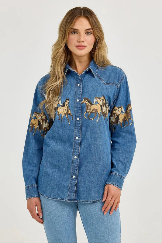 Blue - Women's relaxed-fit, long-sleeve blue denim button-down shirt featuring a prominent graphic print of running horses across the chest and upper sleeves.