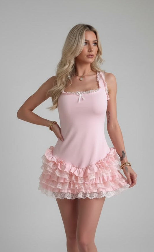 Women's light pink mini dress featuring a fitted bodice, square neckline with a small bow, and a drop-waist skirt with multiple lace-trimmed ruffled tiers.