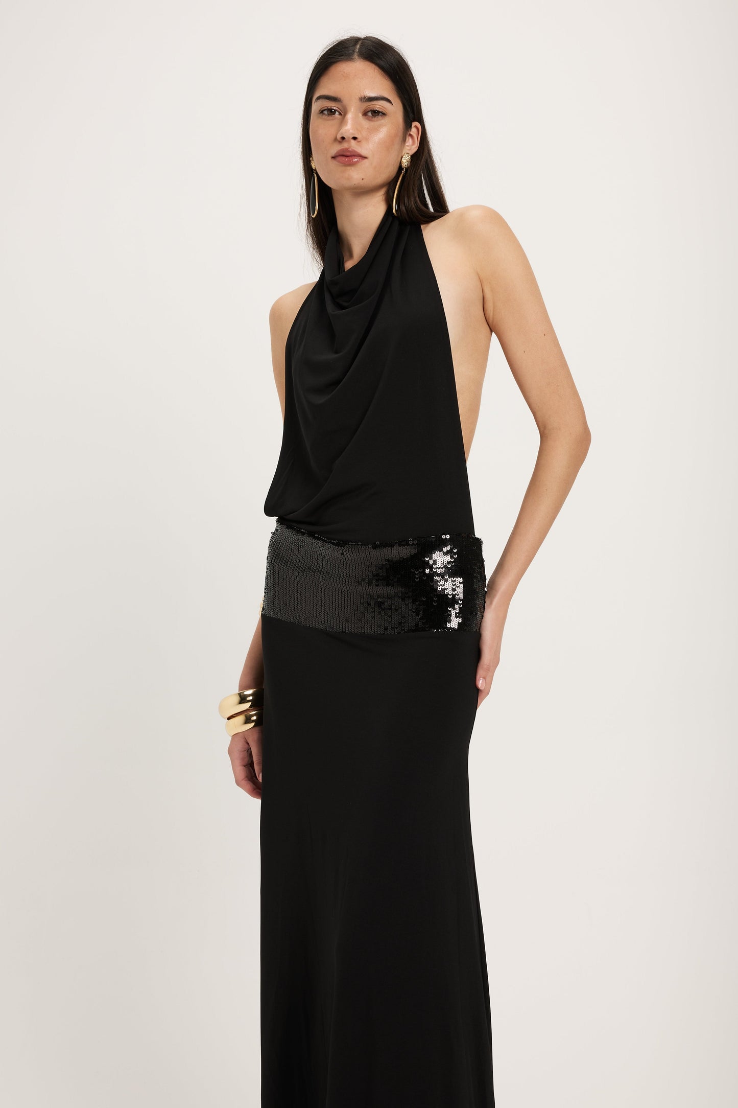 XL - Women's dark red maxi dress featuring a draped cowl halter neckline, an open back, and a wide sequin-embellished band at the waist, falling to a floor-length hem.