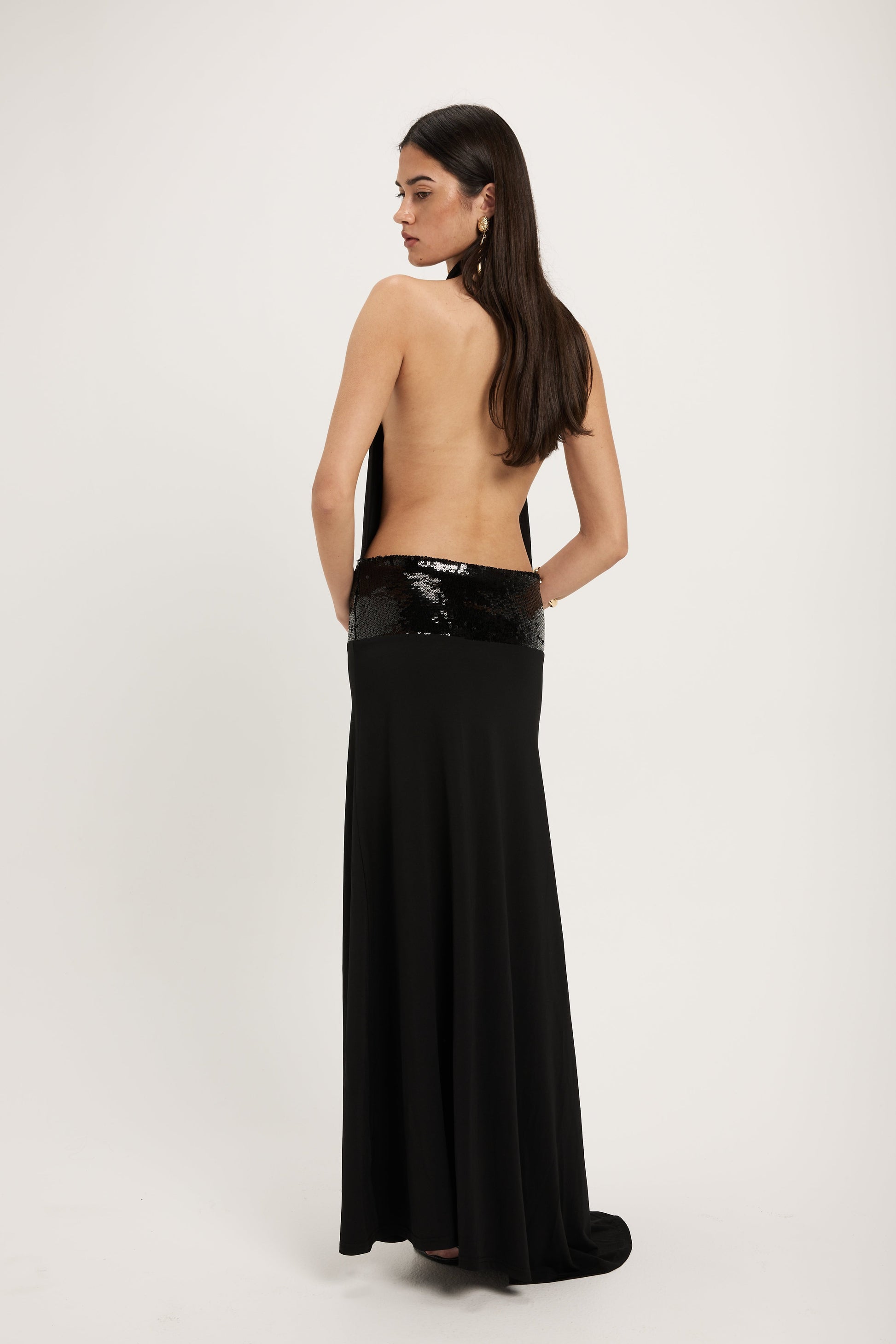 XL - Women's dark red maxi dress featuring a draped cowl halter neckline, an open back, and a wide sequin-embellished band at the waist, falling to a floor-length hem.