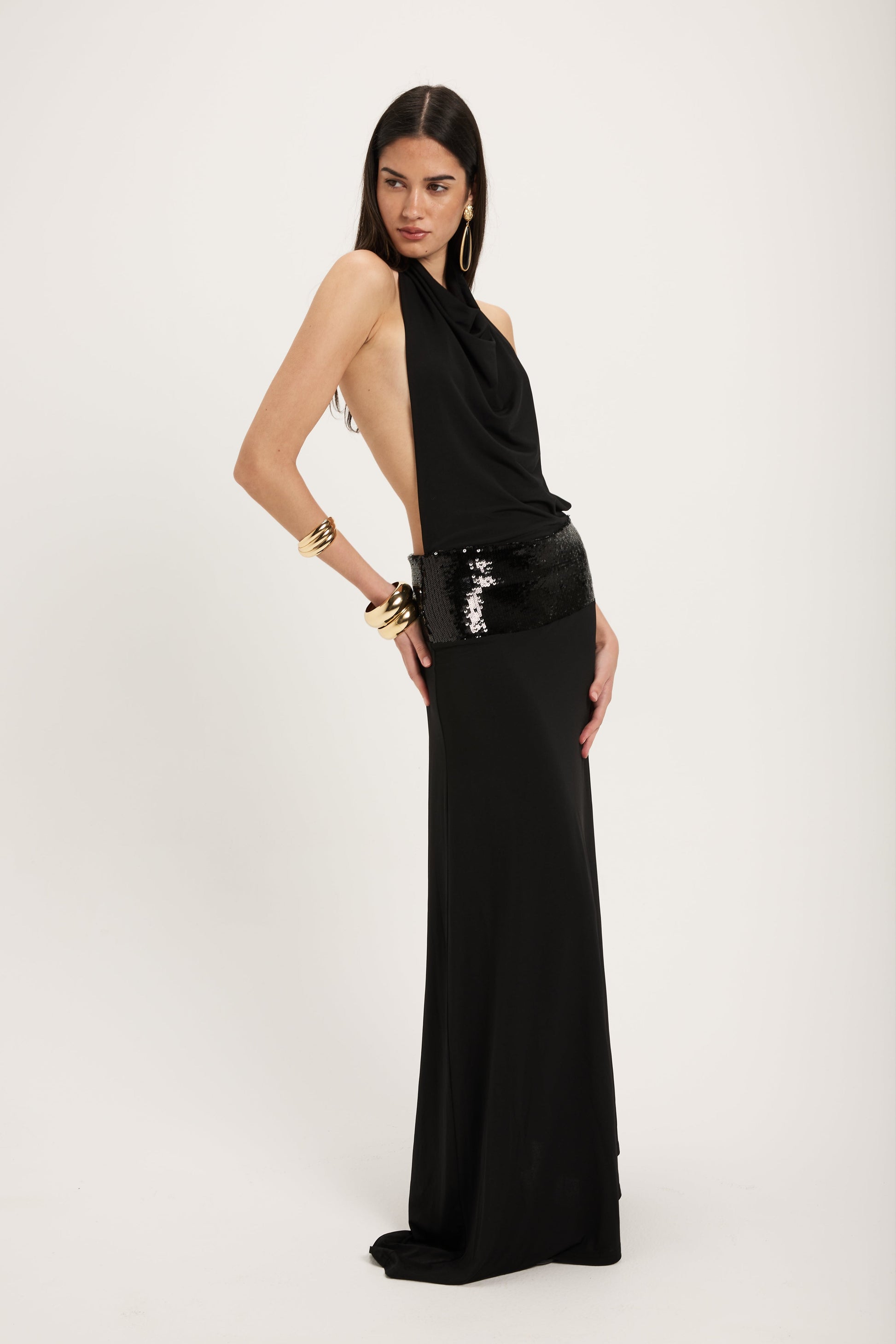 XL - Women's dark red maxi dress featuring a draped cowl halter neckline, an open back, and a wide sequin-embellished band at the waist, falling to a floor-length hem.