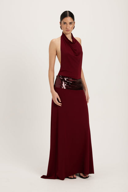 XL - Women's dark red maxi dress featuring a draped cowl halter neckline, an open back, and a wide sequin-embellished band at the waist, falling to a floor-length hem.
