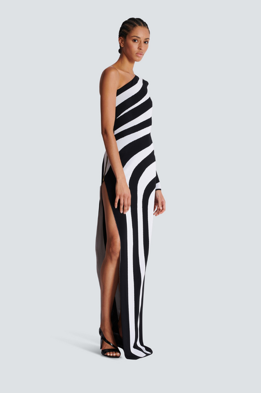 Women's striking one-shoulder maxi dress featuring a bold black and white abstract wavy stripe pattern, a single long sleeve, and a daring high side slit.