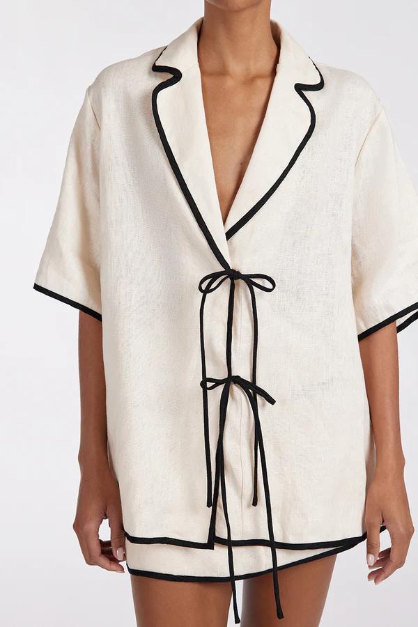 Cream - Women's relaxed fit short-sleeve shirt featuring a notched lapel collar, double tie-front fastening, and dark contrast piping.