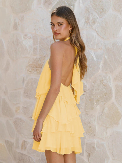 Pink - Women's yellow sleeveless mini dress featuring a halter neckline with a rosette detail and multiple flowing, ruffled tiers in a semi-sheer fabric.