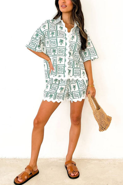Green - Model wearing a pink and red geometric palm print matching co-ord set featuring a short-sleeve button-up shirt and shorts with white scalloped trim.