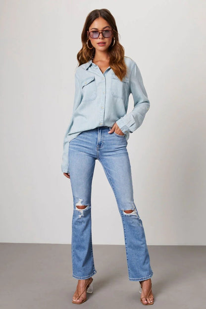 Light Blue - Women's relaxed-fit chambray button-down shirt featuring dual chest pockets and rolled sleeves, styled with denim jeans.