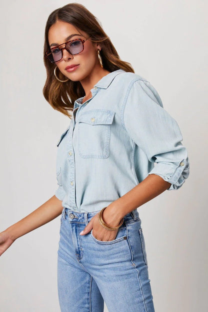 Light Blue - Women's relaxed-fit chambray button-down shirt featuring dual chest pockets and rolled sleeves, styled with denim jeans.