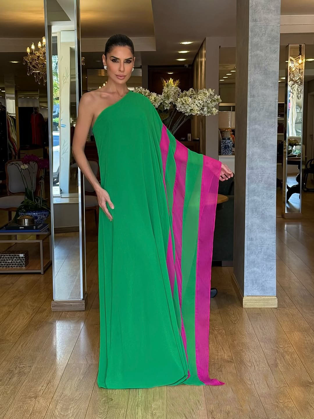 Green - Women's bright green one-shoulder maxi dress featuring a dramatic asymmetrical draped cape sleeve with a vibrant pink contrast trim.
