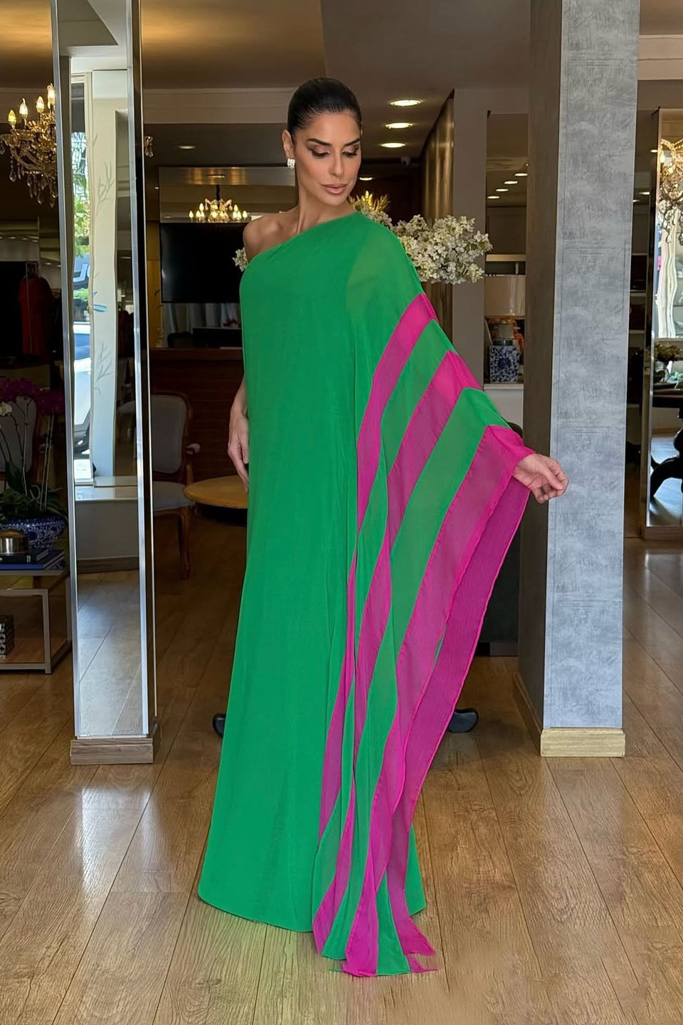 Green - Women's bright green one-shoulder maxi dress featuring a dramatic asymmetrical draped cape sleeve with a vibrant pink contrast trim.