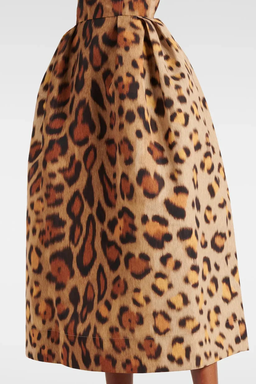 A woman wearing a structured midi dress with a corset bodice and full A-line skirt in a bold leopard print.