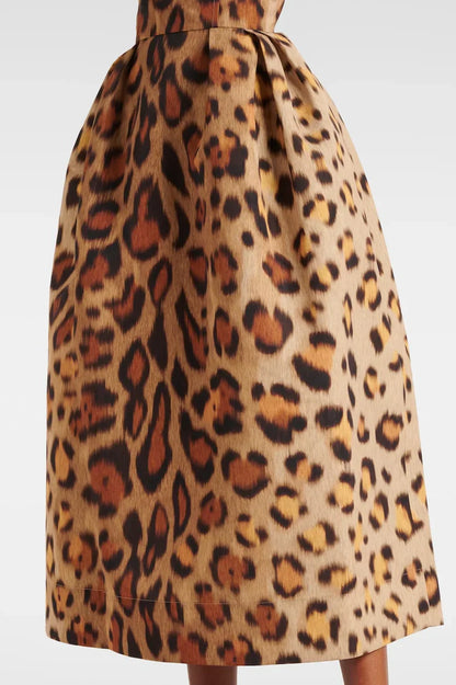 A woman wearing a structured midi dress with a corset bodice and full A-line skirt in a bold leopard print.