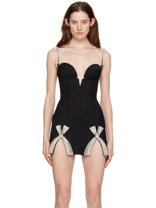 Women's black evening mini dress featuring a structured corset bodice, crystal-embellished straps, and twin front slits decorated with sparkling rhinestone bows.