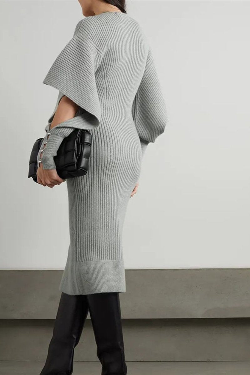 Grey - A woman modeling a cream ribbed knit midi dress with a V-neckline and dramatic split fluted sleeves, holding a brown leather clutch.