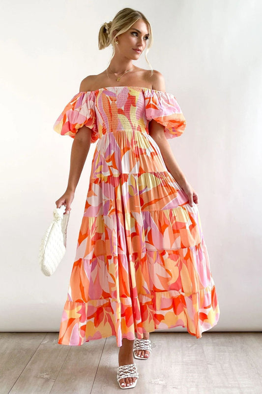 Hot Pink - Women's off-the-shoulder maxi dress featuring a shirred bodice, short puff sleeves, a tiered skirt, and a bright pink, orange, and yellow abstract floral print.