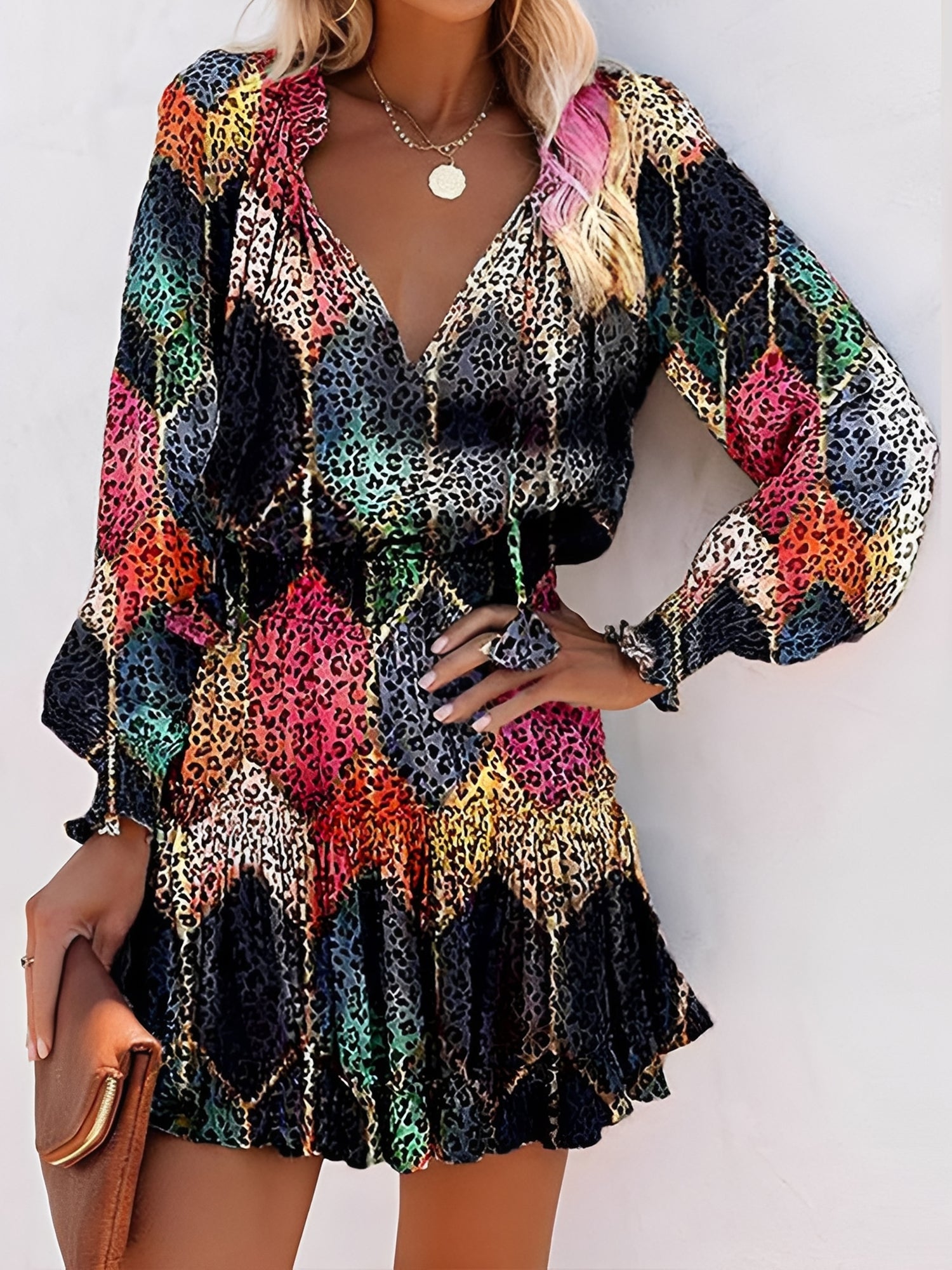 Black - Woman wearing a woven animal-print mini dress with long sleeves, a V-neckline with ties, a smocked waist, and a tiered ruffle skirt.