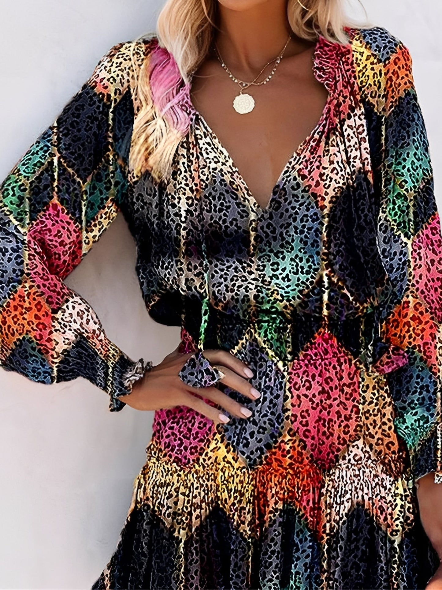 Black - Woman wearing a woven animal-print mini dress with long sleeves, a V-neckline with ties, a smocked waist, and a tiered ruffle skirt.