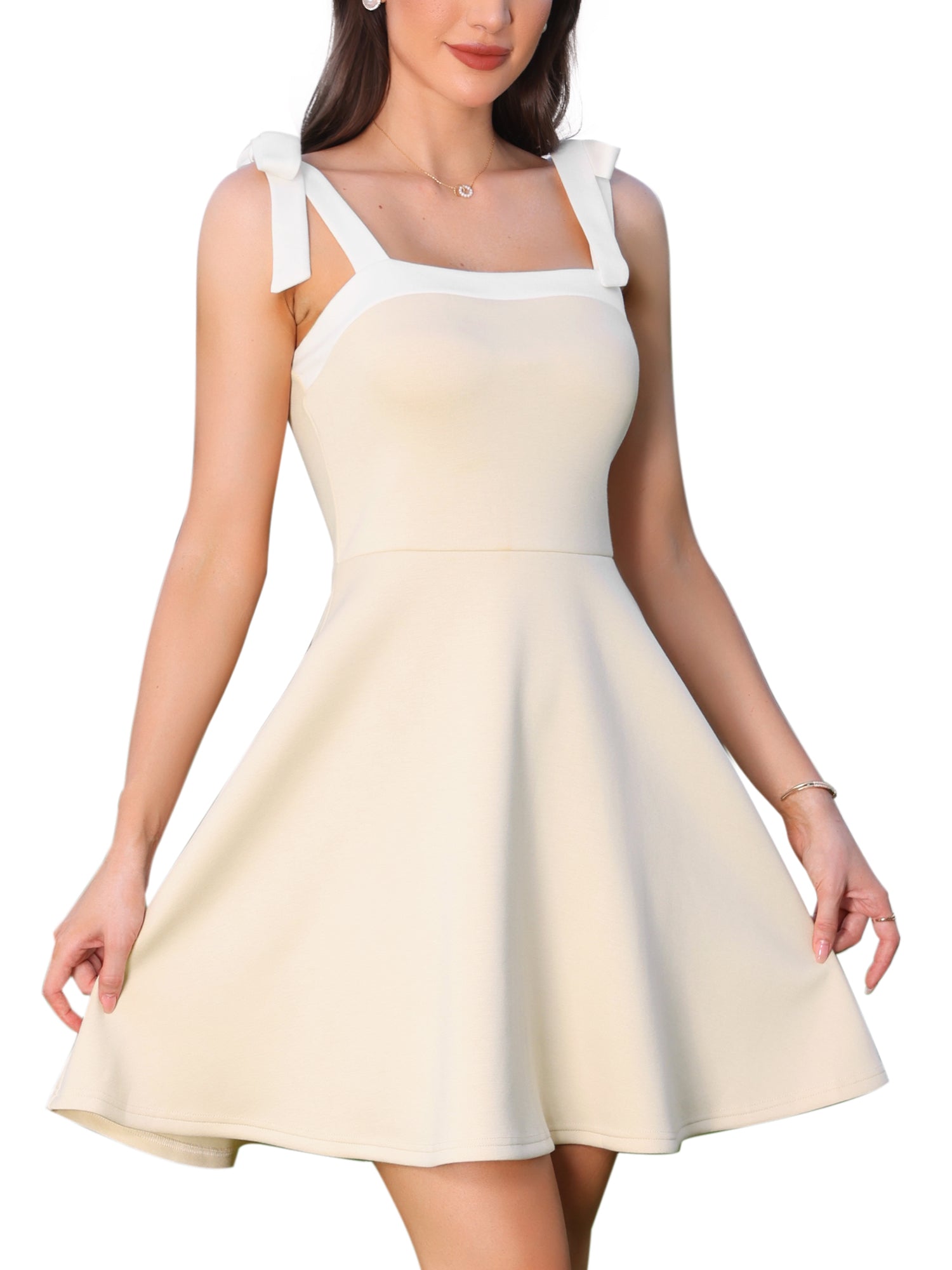 Beige - Woman wearing a structured A-line mini dress with a square neckline, contrast trim, and tie-shoulder straps, standing outdoors holding flowers.