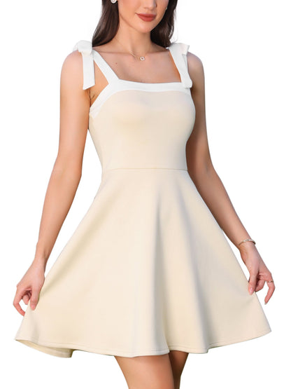 Beige - Woman wearing a structured A-line mini dress with a square neckline, contrast trim, and tie-shoulder straps, standing outdoors holding flowers.