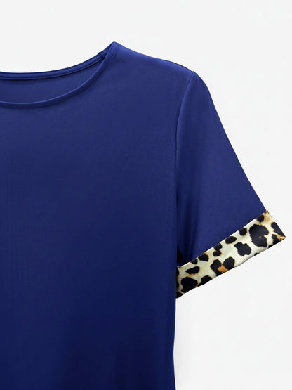 Blue - Woman wearing a short-sleeve shift dress featuring a high crew neckline and contrasting leopard print trim on the sleeves and hem, standing on a balcony.