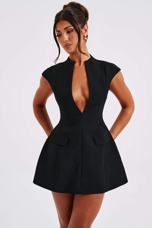 A woman models a black, cap-sleeve mini dress featuring a structured, tailored fit. The dress has a high collar with a deep plunging V-neckline, a cinched waist, two flap pockets, and a flared A-line skirt.