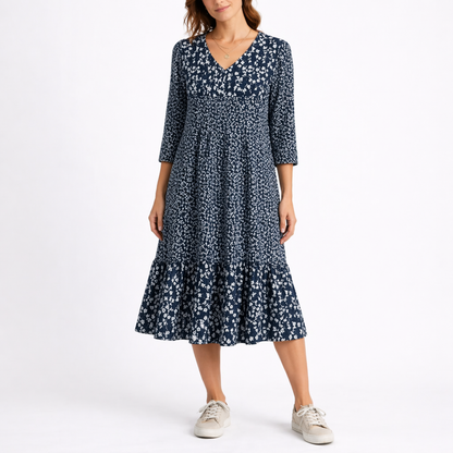 Blue - Model wearing a ditsy floral V-neck midi dress with 3/4-length sleeves and a tiered hemline.