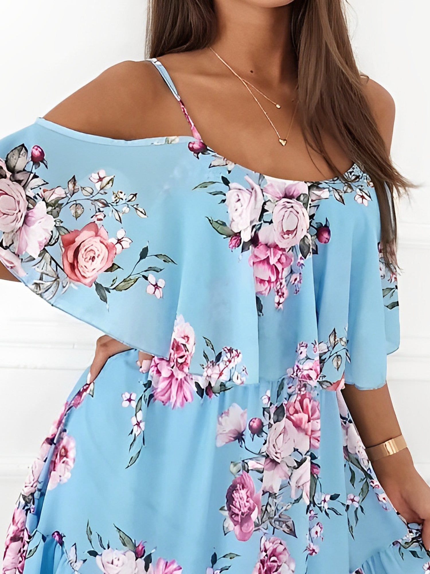 Light Blue - Woman wearing a floral print cold-shoulder tiered dress with a ruffle overlay neckline.