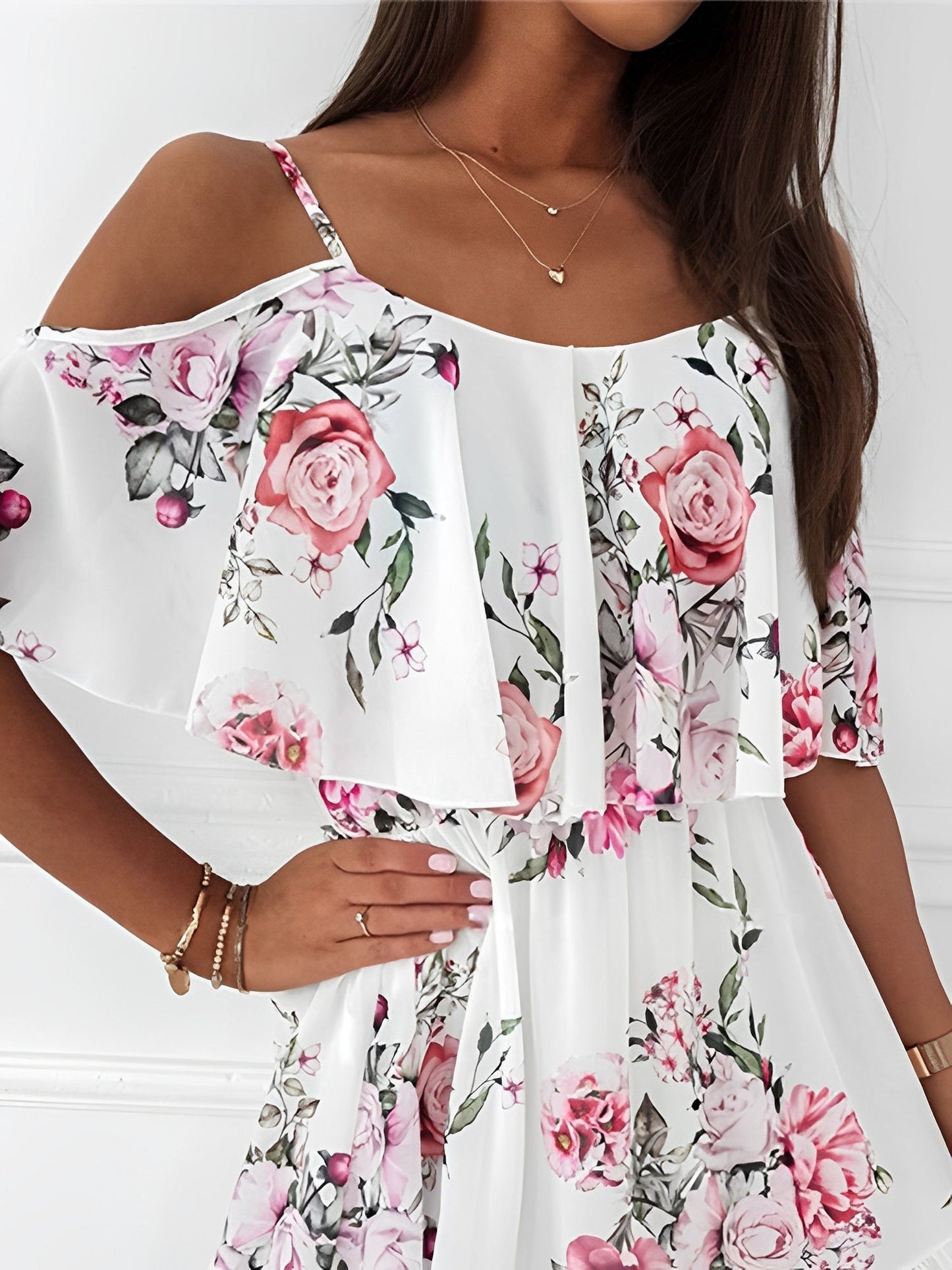 White - Woman wearing a floral print cold-shoulder tiered dress with a ruffle overlay neckline.