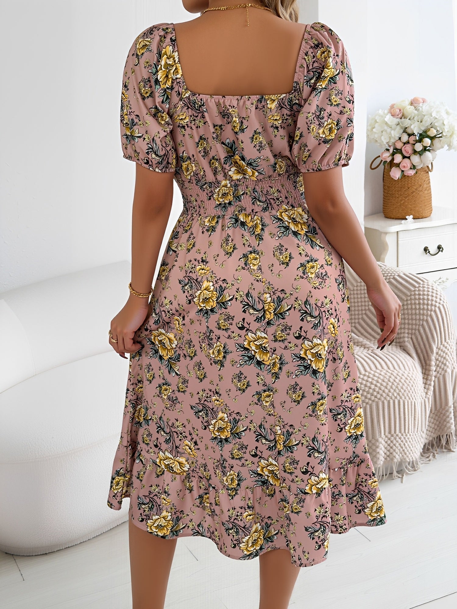 Pink - Woman wearing a floral print off-the-shoulder midi dress with a smocked waist and short puff sleeves, holding a woven straw bag