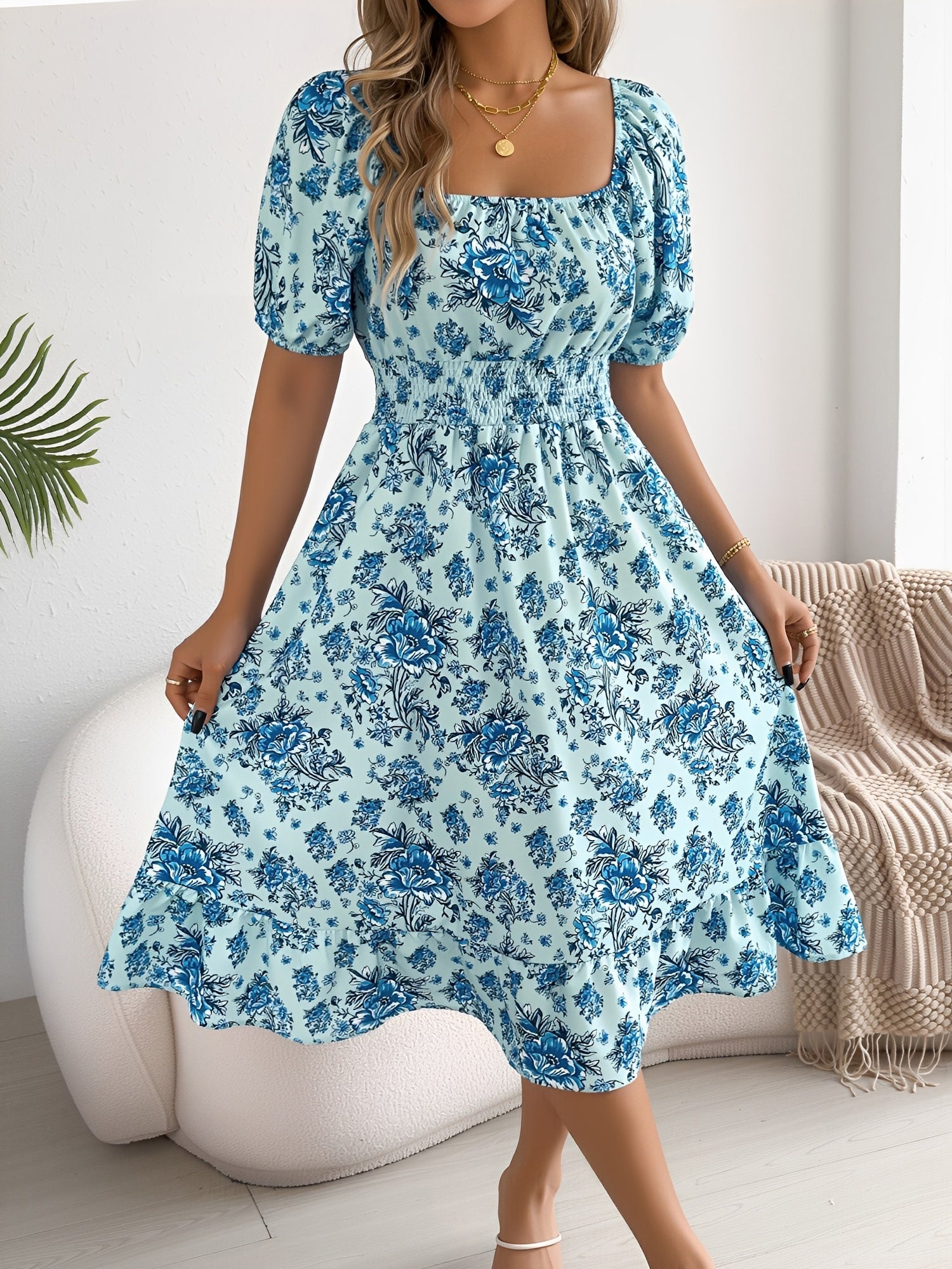 Blue - Woman wearing a floral print off-the-shoulder midi dress with a smocked waist and short puff sleeves, holding a woven straw bag