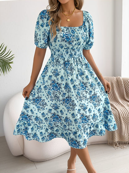 Blue - Woman wearing a floral print off-the-shoulder midi dress with a smocked waist and short puff sleeves, holding a woven straw bag
