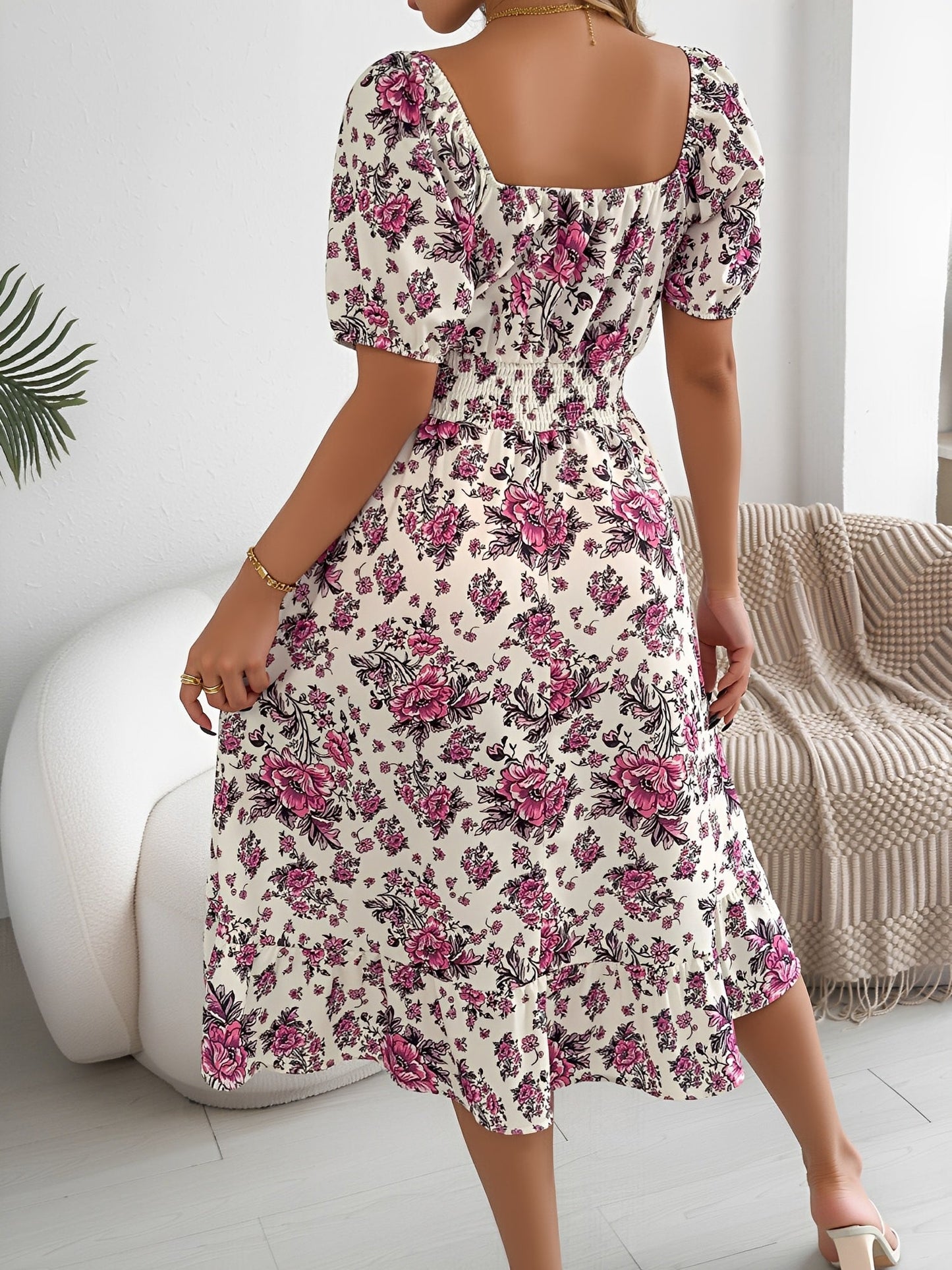White - Woman wearing a floral print off-the-shoulder midi dress with a smocked waist and short puff sleeves, holding a woven straw bag