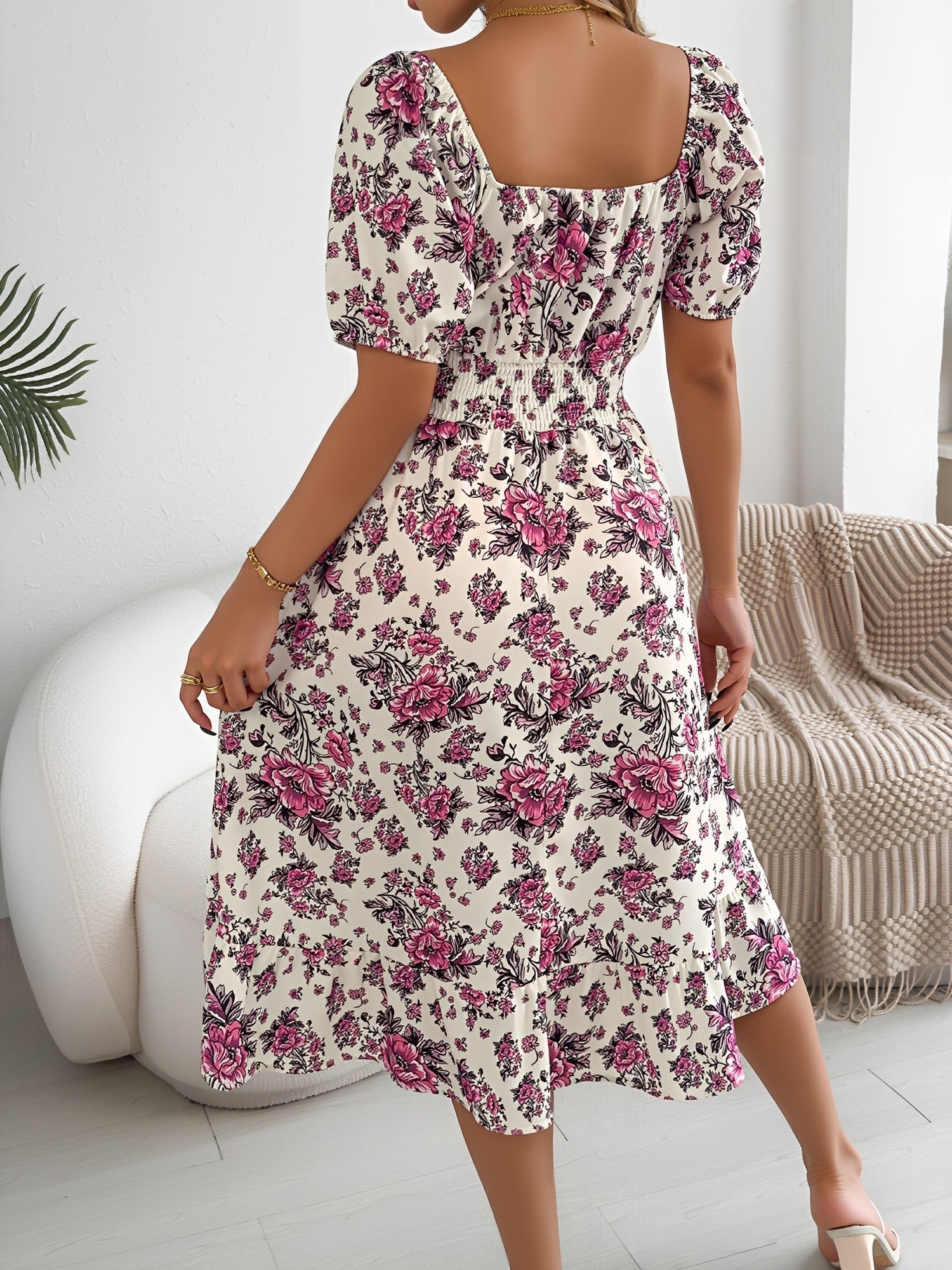 White - Woman wearing a floral print off-the-shoulder midi dress with a smocked waist and short puff sleeves, holding a woven straw bag