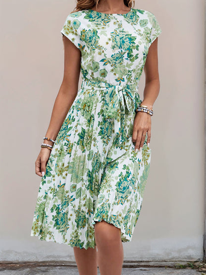 Green - Woman wearing a woven floral cap-sleeve midi dress with a self-tie waist and pleated skirt.