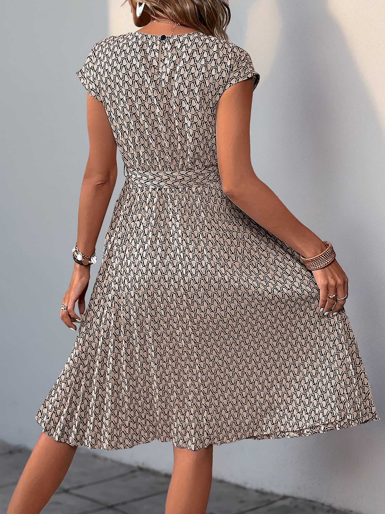 Khaki - Woman wearing a woven floral cap-sleeve midi dress with a self-tie waist and pleated skirt.